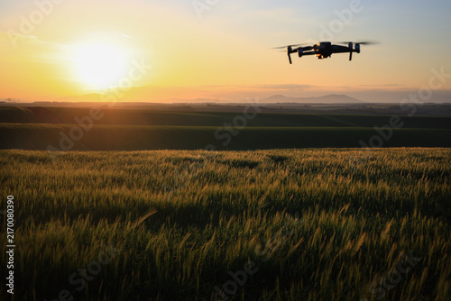 A photo of a grain field monitored by a drone during sunrise