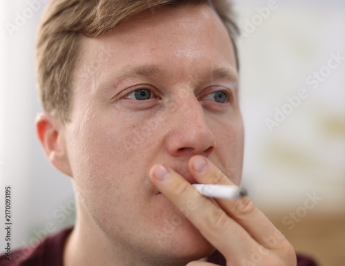 Fotografie Man smoking cigarette on blurred background. Bad habit