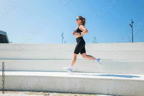 Canvastavla Runner enjoying a sunny day while jogging on outdoor steps in a modern urban set