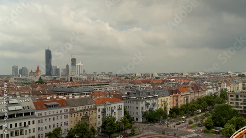 4K video of Vienna, Austria skyline featuring modern high-rise buildings contrasting with traditional red-roofed architecture, cloudy day cityscape view
