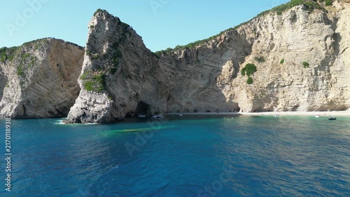 4K Aerial forward motion over Chomi Beach with turquoise sea and limestone cliffs in Corfu, Greece