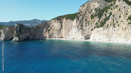 4K Rising aerial view of Chomi Beach and anchored boats near Paleokastritsa, Corfu