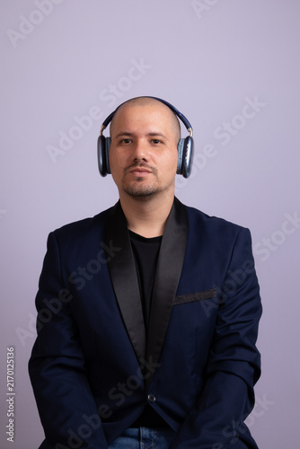 Foto Man in blue blazer wearing wireless over ear headphones