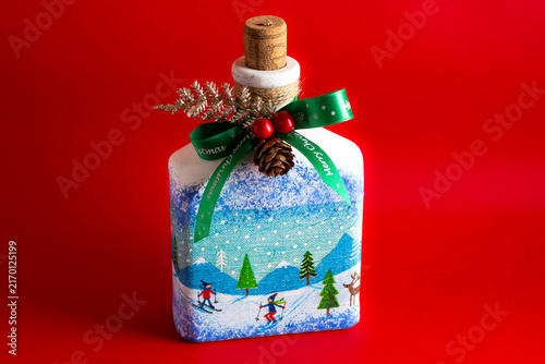 Foto Handmade Christmas bottle at an angle on red background