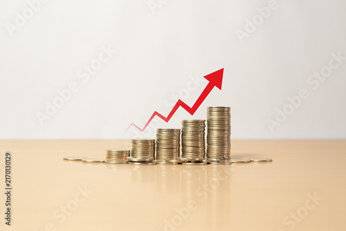 Quadro su tela Stacked coins with rising red arrow representing inflation concept, increasing c