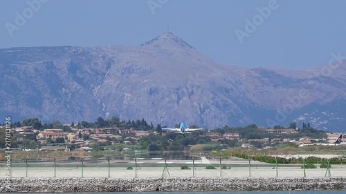 Telephoto shot showing TUI plane taking off at Corfu Airport with mountain backdrop