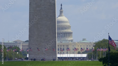 Extreme long shot of the Washington Monument and U.S. Capitol in Washington, DC, as the new Air Force One flies in the distant sky. 15345  