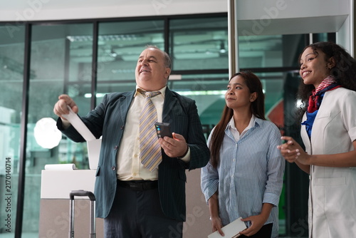 Obraz na płótnie An older traveller and two young women react to the information the agent gives