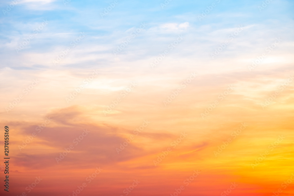Fototapeta premium Sunset or sunrise sky with a vibrant gradient of orange, gold, and soft blue. Clear atmosphere with wispy clouds. Peaceful, natural light background. hope, freedom, new day and inspirational Concepts