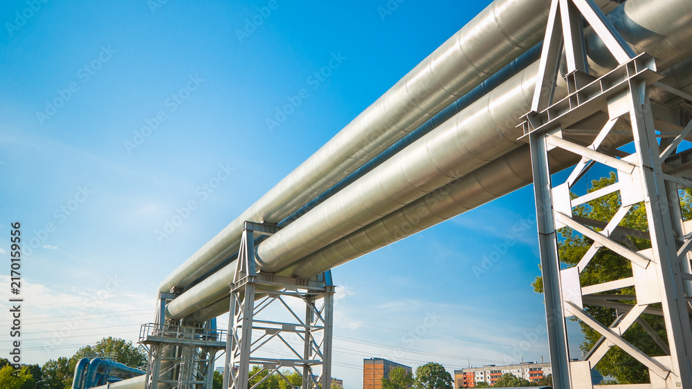Fototapeta premium The photograph shows a pipeline on metal supports against a blue sky