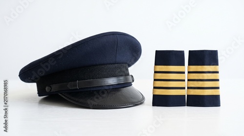 фотографія Pilot uniform cap and epaulets with gold stripes on a white background
