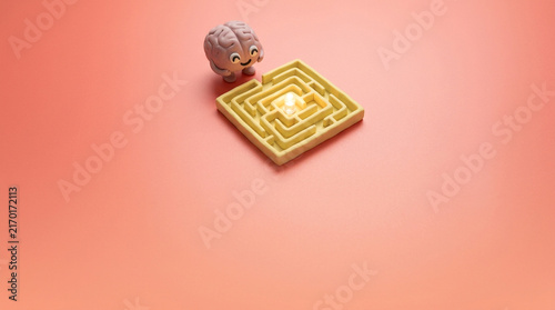 Brain Navigating Maze Toward Glowing Lightbulb Concept