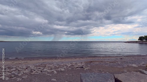 Rain shaft or rain curtain over Lake Ontario, view from a beach in Bluffers Park, Scarborough, Ontario, Canada