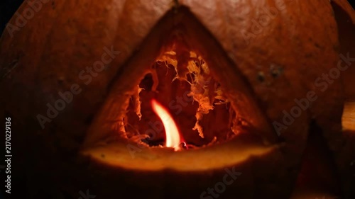 Spooky 4K Seamless Loop Carved Jack-o'-Lantern with Flickering Orange Flame and Interior Pulp Texture in Dark Background