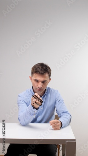 Fotografie Man holding rosary beads in both hands, eyes closed in quiet prayerful meditatio