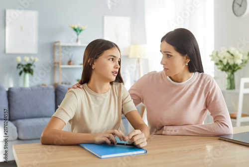 Cuadro en lienzo Mother and daughter discuss school problem at home, sitting at table in living room