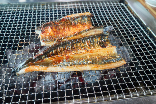 Fotografie Premium raw eel fillets roasting over a hot charcoal grill capturing an authenti
