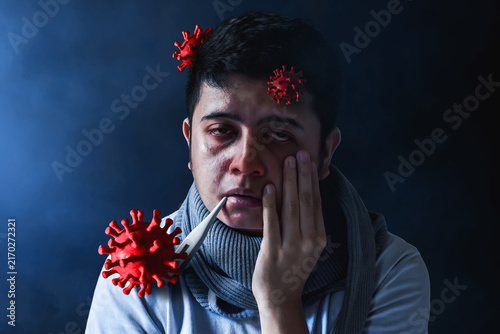 Sick young man and red virus cells on dark background