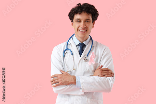 Breast cancer awareness and prevention, smiling male doctor with pink ribbon ...