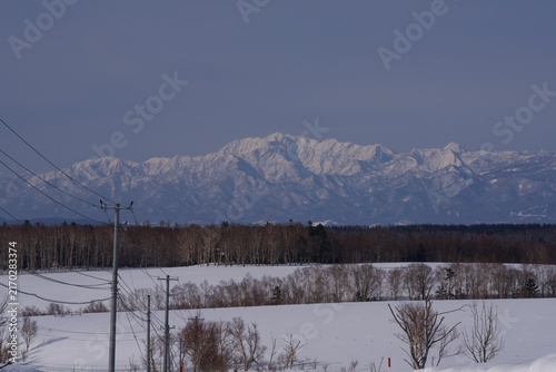 Foto White winter mountain range seen from the edge of town, Hokkaido, Japan