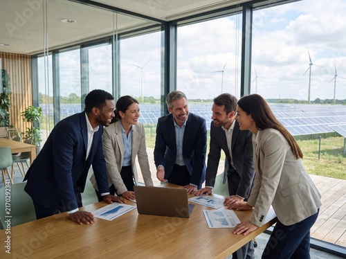 Diverse business team collaborating on a strategy meeting in a modern office with renewable energy with business professionals formal attire collaborating around