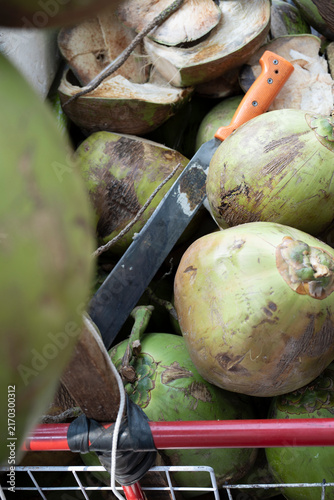 a closeup of a machete and green coconuts