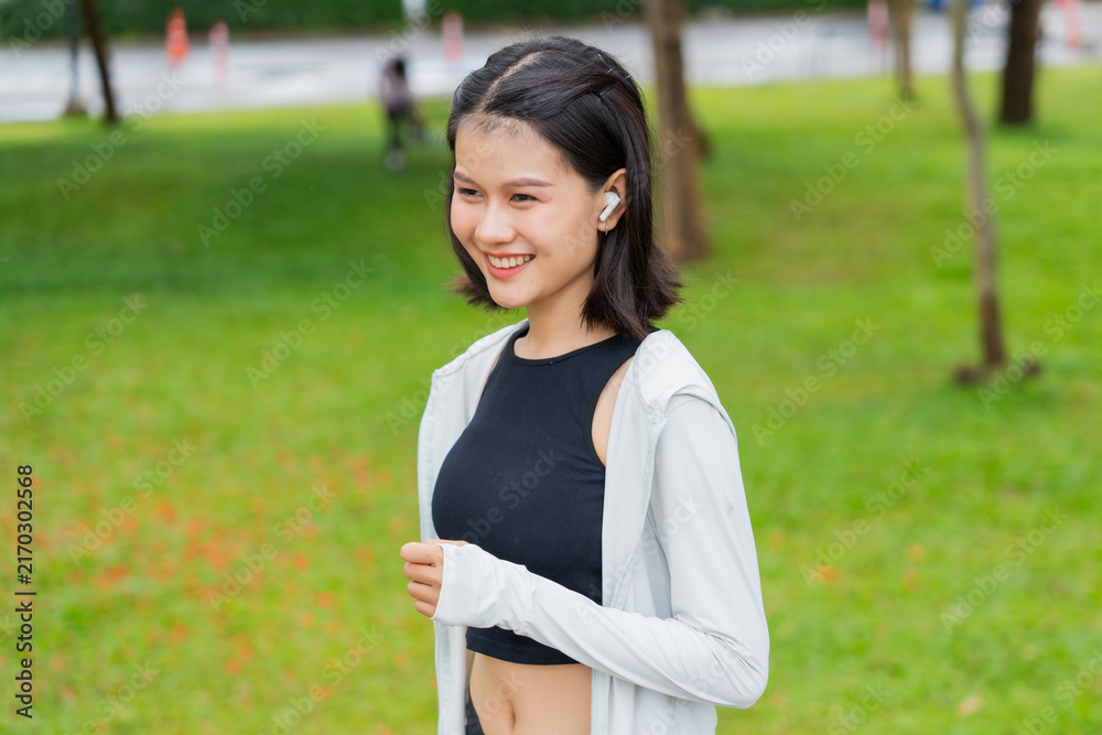 Naklejka premium Asian sporty woman running in public park