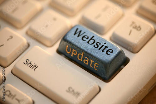 A close-up shot of a keyboard featuring a custom website update key with warm lighting. Ideal for internet maintenance and digital marketing themes.