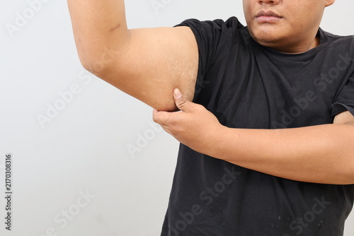 Obraz na plátne A close-up photo of a heavy-set man showing off his arm muscles while gripping his own arm