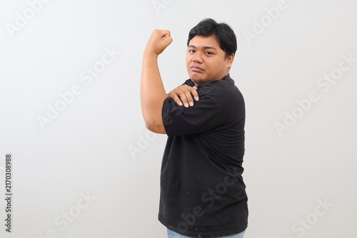 Foto A heavy-set man poses, showing off his biceps against a white studio background
