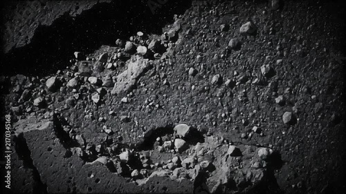 Close up of cracked concrete surface with rough texture and broken stones in black and white