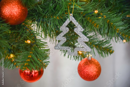 Close-up view of Christmas gifts under a decorated tree with red wrapping in a cozy home interior.