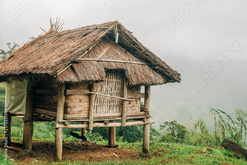 Canvastavla Close view of a traditional bamboo hut with a thatched roof on a green mountain