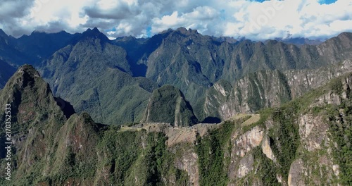 Aerial view of the Historic Sanctuary of Machu Picchu with ancient stone ruins and agricultural terraces set against the dramatic Andes mountains in Peru
