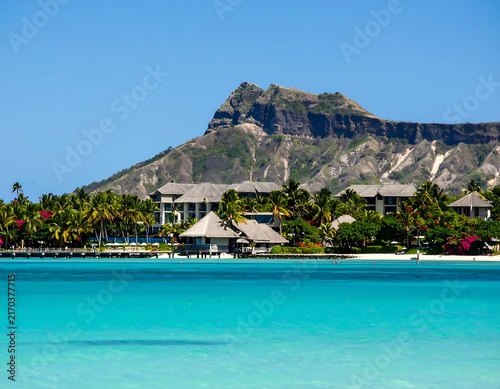 Tropical paradise with clear blue water and rocky cliffs.