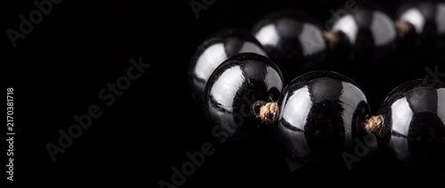 Glossy black prayer beads strung on rough twine, used in meditation and spiritual practices with dark background.