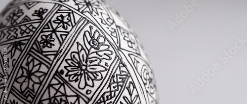 Decorative white egg with intricate black line art patterns, traditional folk design for easter and cultural celebrations.