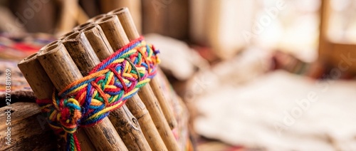 Traditional south american pan flute with vibrant colorful woven band, handcrafted musical instrument for cultural music.