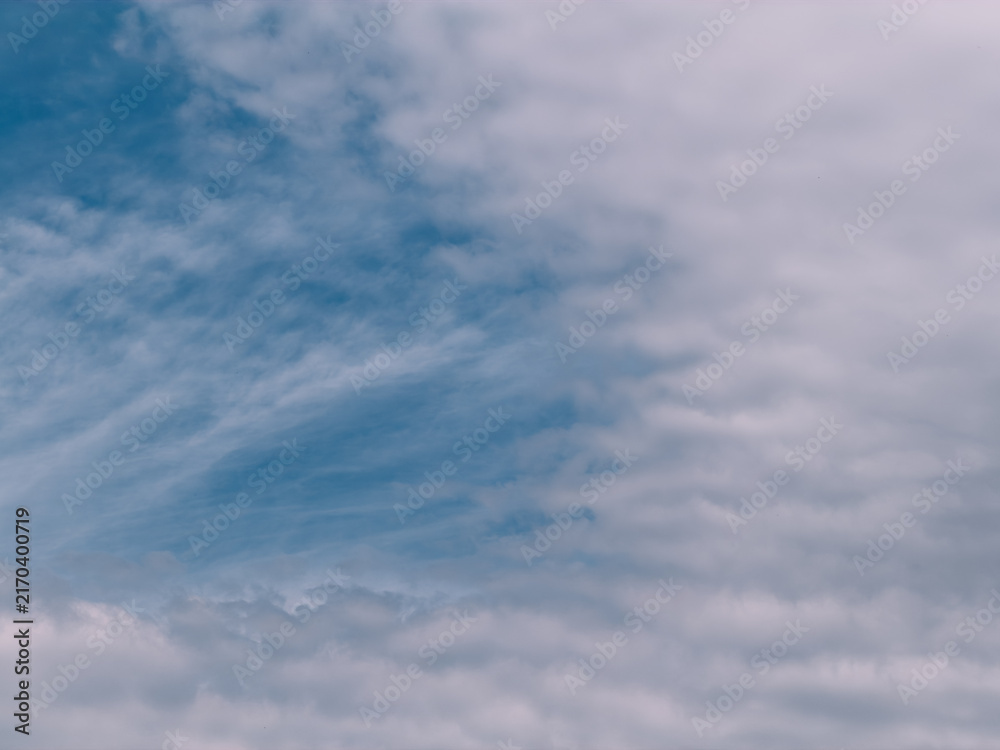 Obraz premium Soft rippled clouds spreading across blue sky, natural abstract background.