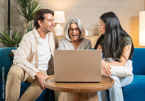 Foto Family members expressing surprise and happiness while looking at a laptop scree