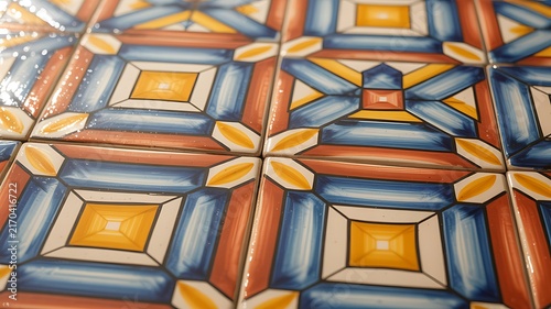 Vibrant ceramic floor tiles featuring intricate geometric patterns with warm yellow blue and terracotta glazed colors