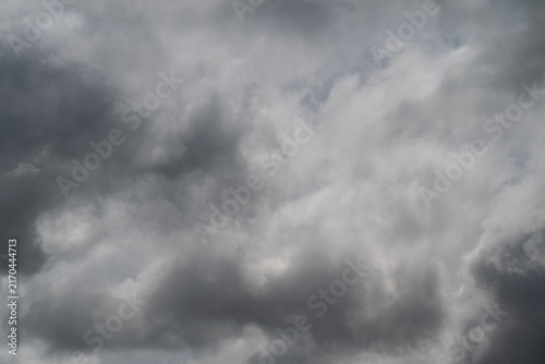 Foreboding storm approaching. Gray clouds signal impending rain. Dark rainclouds loom with threatening atmosphere. Heavy gray skies forewarn of upcoming torrential rainstorm
