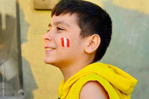 Obraz na plátne Excited little peruvian with national flag painted on cheeks.