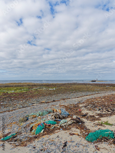 фотографія Old Discarded nets, ropes and Fishing equipment strewn along the high water mark along the Beach at Cairnbulg with a Wreck seen in the distance
