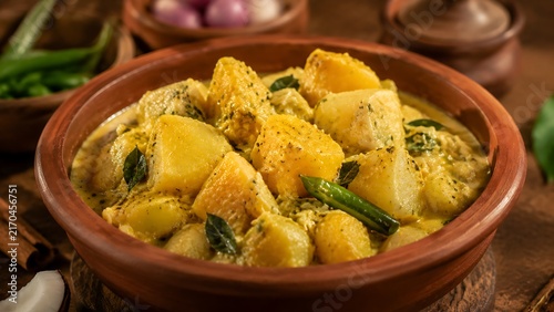 Traditional Sri Lankan manioc curry with cassava pieces cooked in coconut milk and spices, served in clay bowl with authentic village cuisine and vegetarian food culture
