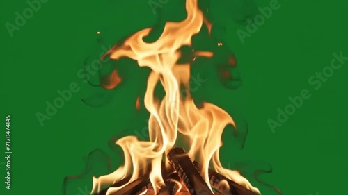 Campfire burning with bright orange flames over wood logs, green screen video 4K. heat hot warmth fire