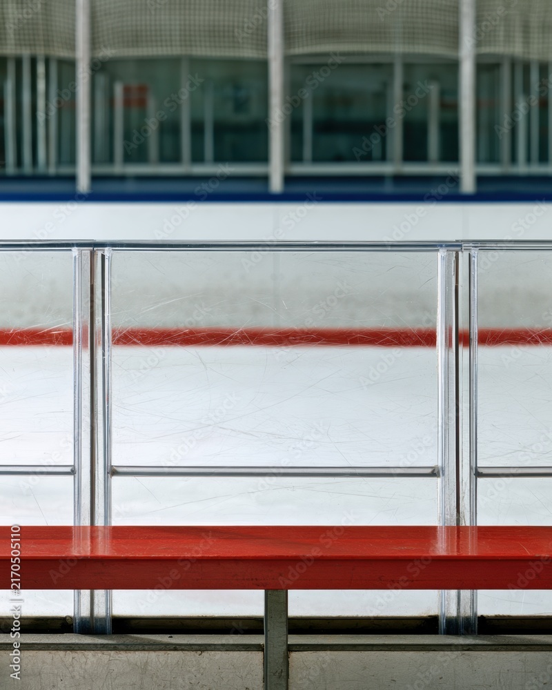 Fototapeta premium Ice hockey arena bench with scratched plexiglass boards and red railing for sports design poster background
