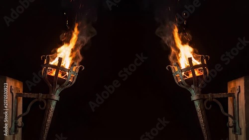 Two medieval torches burning brightly at night with flames and smoke.