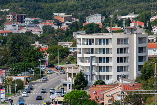 Modern apartment building and busy street surrounded by residential houses in Sutomore, Montenegro