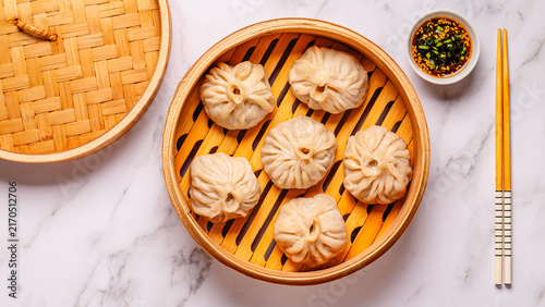 Steaming basket filled with dumplings on a marble table